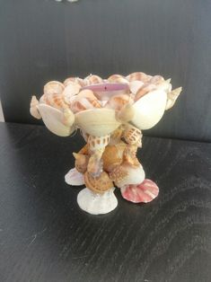 a vase filled with seashells on top of a table