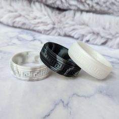 two black and white bracelets sitting on top of a marble counter