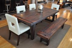 a wooden table with white chairs and a bench in front of it on a hard wood floor