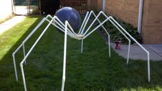 a spider web sculpture in front of a house