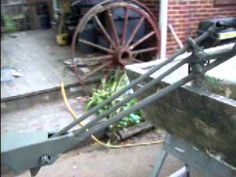 an old wagon sitting in front of a brick building next to a pile of bananas