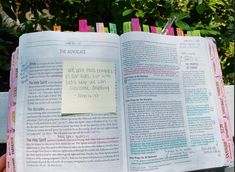 an open bible with sticky notes attached to it