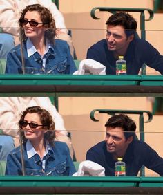 two people are sitting in the stands at a tennis match and one is holding a water bottle