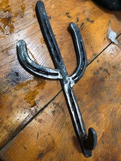 a pair of metal scissors sitting on top of a wooden table next to a hammer