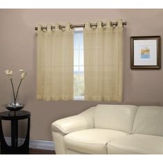 a living room with white furniture and curtains