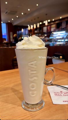 a cup with whipped cream in it sitting on a table