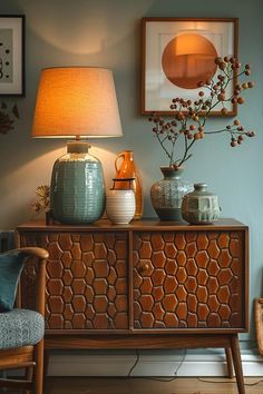 a table with two vases on it and a lamp in the corner next to it