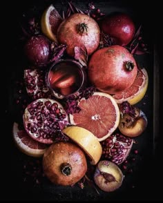 an assortment of fruit including pomegranates, oranges and pears