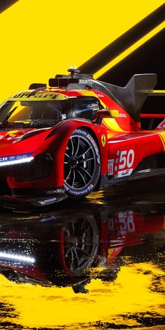 a red race car is parked in front of a bright yellow and black background with reflections on the floor