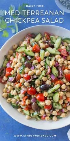 a white bowl filled with chickpea salad on top of a blue table