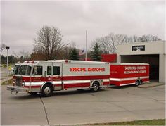 a red and white fire truck parked in front of a building