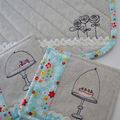 two bibs with designs on them and one has a cake in the middle, while the other has an umbrella