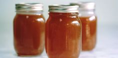 three jars filled with liquid sitting on top of a table