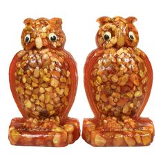 two owl figurines made out of corn on the bottom and one has eyes wide open