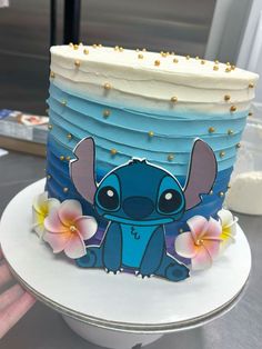 a blue and white cake with an image of stitching lillies on the side