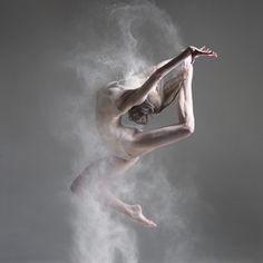 a person jumping in the air on a skateboard with dust behind them and white background