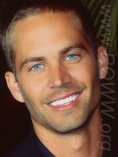 a man with blue eyes smiling for the camera