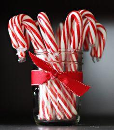 a jar filled with candy canes on top of a table