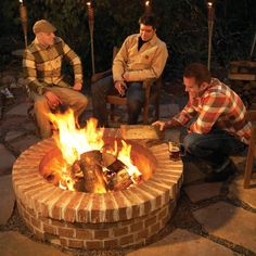 three men sitting around an outdoor fire pit