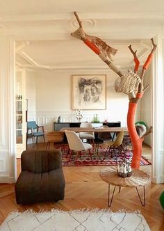 a living room filled with furniture and a cat tree in the middle of the room