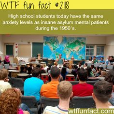 a group of people sitting in front of a classroom with a map on the wall