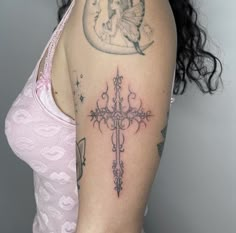 a woman with a cross tattoo on her left arm and the moon behind her shoulder