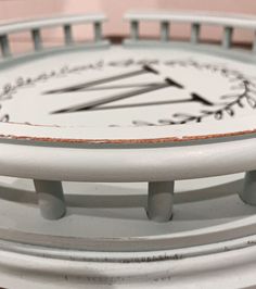 a white clock with roman numerals on it's face is shown in close up