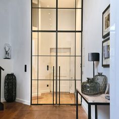 an entry way with glass walls and wooden floors