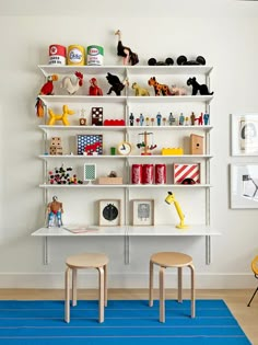 a child's playroom with toys and bookshelves on the wall above it