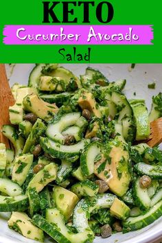 cucumber avocado salad in a white bowl with a wooden spoon on the side