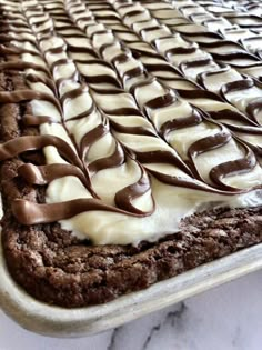 a cake with white frosting and chocolate swirls sitting on top of a counter