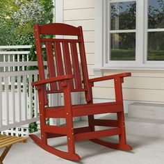 a red rocking chair sitting on top of a porch