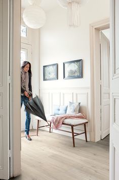 a woman is holding an umbrella in the living room