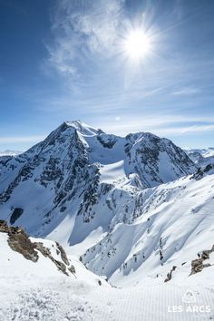 the sun shines brightly over snowy mountains