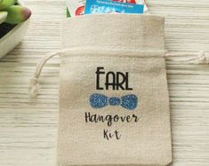 a small bag with the words ear hangover kit on it next to some succulents