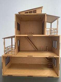 a wooden model of a house with stairs and balconies on the second floor