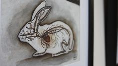 a drawing of a white rabbit is hanging on the wall