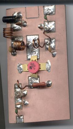 an assortment of electrical components are displayed on a piece of pink paper with metallic foil