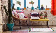 a living room filled with furniture and lots of potted plants on the windowsill