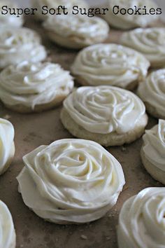 white frosted cupcakes sitting on top of a cookie sheet covered in icing