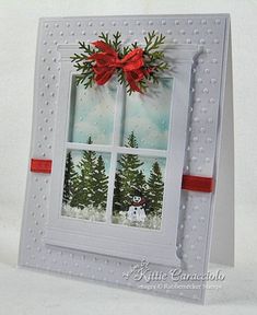 a white card with a red bow on the window and snowman in the background