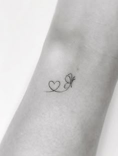 a small heart tattoo on the wrist