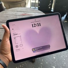 a person holding up a tablet with a heart on it