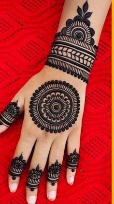 a woman's hand with henna tattoos on it and the bottom half of her arm