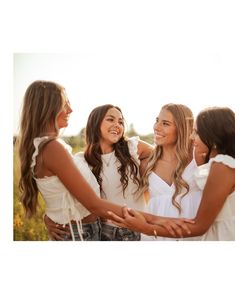 four girls are standing in a circle and one girl is holding the other's hand