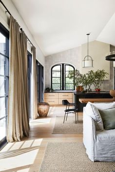 a living room filled with furniture and lots of windows