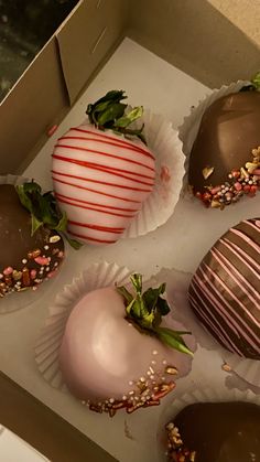 four chocolate covered strawberries sitting in a box on top of a counter next to each other