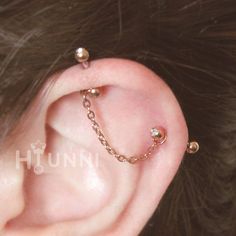 an ear piercing is shown with gold chains