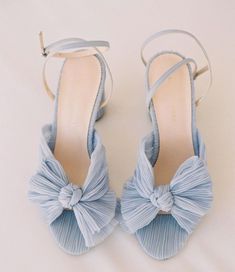 a pair of blue high heeled shoes with a bow