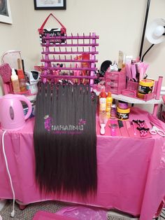 there is a pink table with lots of hair on it and other items in the background